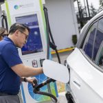 Commerce Director Joe Nguyễn plugs his car into one of the available Skycharger stations during the grand opening of the states first electric vehicle fast-charging station on Tuesday, June 24, 2025 in Arlington, Washington. (Olivia Vanni / The Herald)