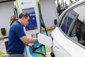 Commerce Director Joe Nguyễn plugs his car in to one of the available Skycharger stations during the grand opening of the state’s first electrical vehicle fast-charging station on Tuesday, June 24, 2025 in Arlington, Washington. (Olivia Vanni / The Herald)
