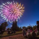 People watch fireworks over Lake Ballinger from Nile Shrine Golf Course on Thursday, July 3, 2025 in Mountlake Terrace, Washington. (Olivia Vanni / The Herald)