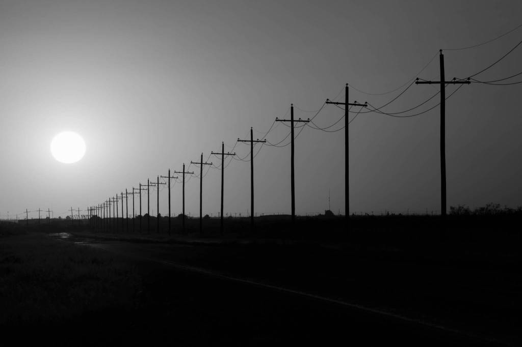 Paul Ratje / The New York Times
The sun sets over power lines in rural Ward County, Texas on May 20, 2025. Republicans terminated billions of dollars in clean energy tax credits with passage of the One Big Beautiful Bill Act. Experts say that will mean more greenhouse gas emissions and more dangerous heat.