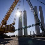Wind turbine tower sections, which will be transported vertically to the South Fork Wind site off Long Island in New York, are raised into place in New London, Conn., Nov. 20, 2023. By ending tax credits for wind and solar power, Senate Republicans have jeopardized billions in investments in their own districts. (Joe Buglewicz / The New York Times)