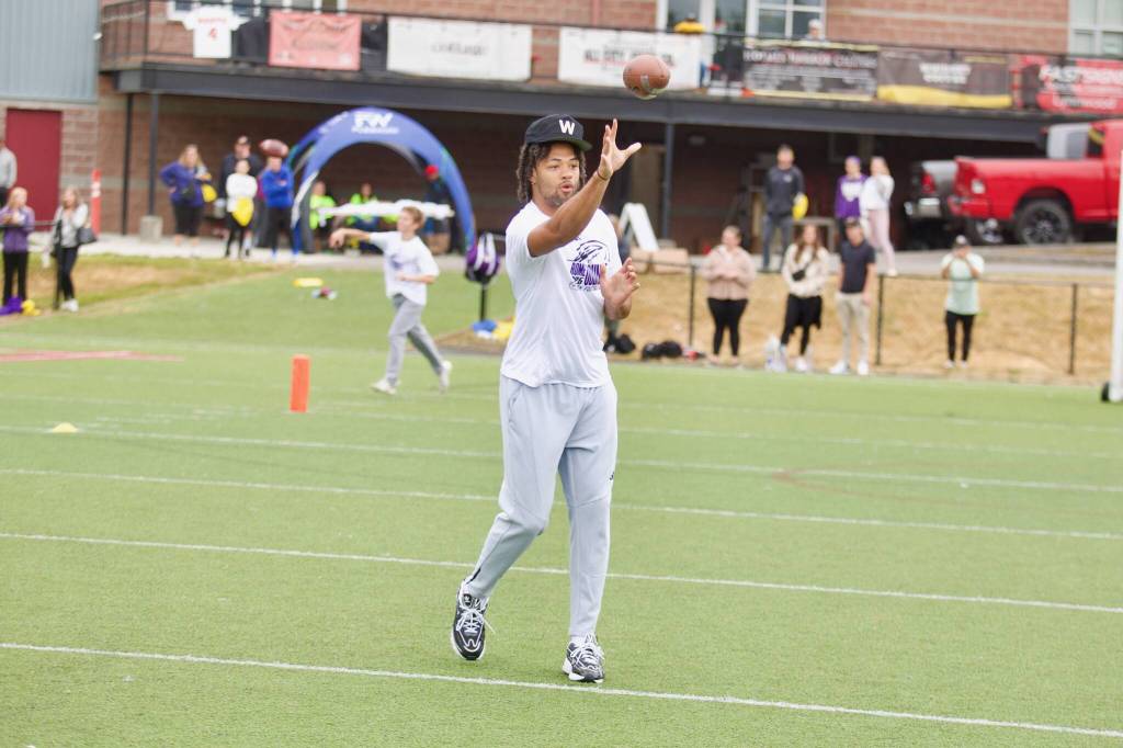 Rome Odunze tosses a football during his youth football camp at Archbishop Murphy High School on July 10, 2025. (Joe Pohoryles / The Herald)