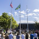 People gather for the flag raising outside of the new City of Monroe buildings on Monday, July 14, 2025 in Monroe, Washington. (Olivia Vanni / The Herald)