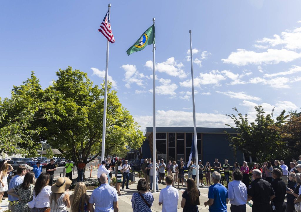 People gather for the flag raising outside of the new City of Monroe buildings on Monday, July 14, 2025 in Monroe, Washington. (Olivia Vanni / The Herald)