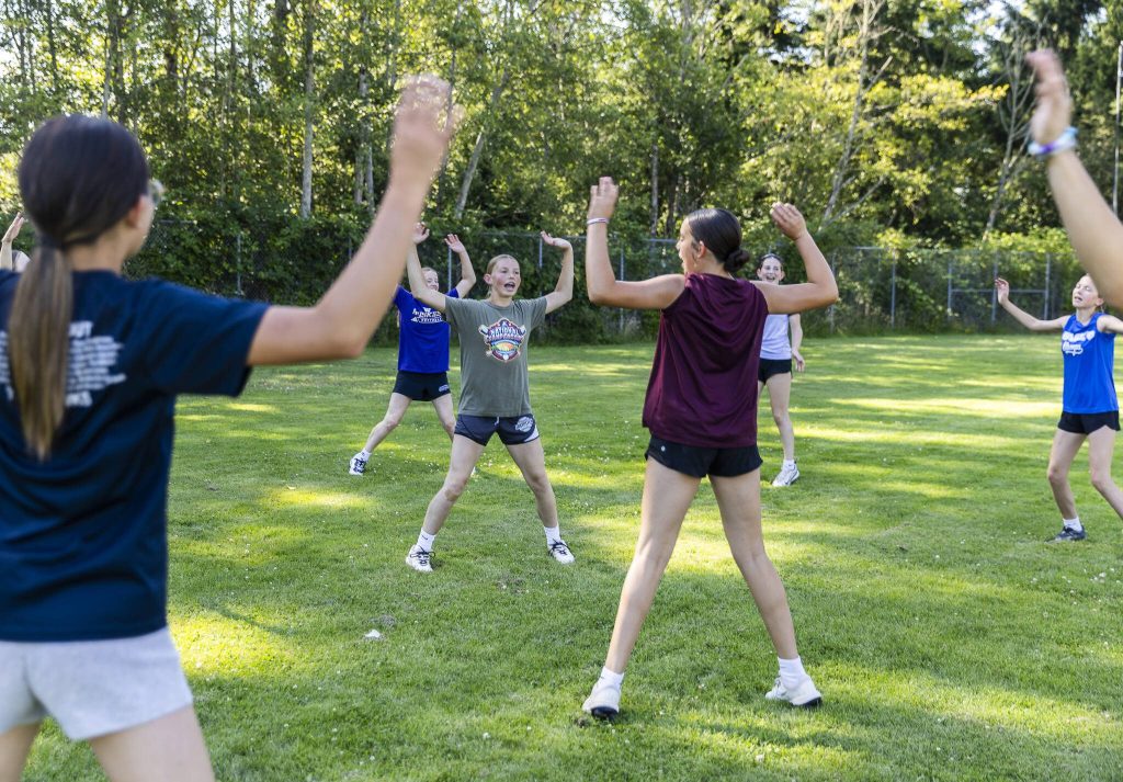 Anya Miller, 13, helps run warm up exercises before practice on Wednesday, July 16, 2025 in Mill Creek, Washington. (Olivia Vanni / The Herald)