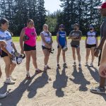 Mill Creek Little League softball infield players listen to their coach before running drills on Wednesday, July 16, 2025 in Mill Creek, Washington. (Olivia Vanni / The Herald)