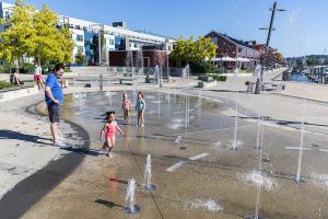 Skylar Maldonado, 2, runs through the water at Pacific Rim Plaza’s Splash Fountain, one of the newer features add to the Port of Everett waterfront on Tuesday, July 15, 2025 in Everett, Washington. (Olivia Vanni / The Herald)