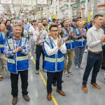 Richard Wong, center, the 777-X wing engineering senior manager, cheers as the first hole is drilled in the 777-8 Freighter wing spar on Monday, July 21, 2025 in Everett, Washington. (Olivia Vanni / The Herald)