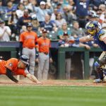 Shay Whitcomb (10) of the Houston Astros looks to avoid Mitch Garver (18) of the Seattle Mariners tag at home plate to score off of Cam Smiths two-run RBI double during the fifth inning against the Seattle Mariners at T-Mobile Park on Sunday, July 20, 2025, in Seattle. (Alika Jenner / Getty Images / Tribune News Services)