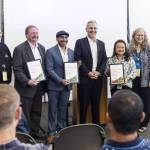 Doug McCormick (left to right), Dave Somers, Oscar Fuentes, Josh Brown, Clarissa Barrett and Kellie Snyder pose with Vision 2050 awards on Monday, July 28, 2025 in Everett, Washington. (Olivia Vanni / The Herald)