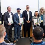 Doug McCormick (left to right), Dave Somers, Oscar Fuentes, Josh Brown, Clarissa Barrett and Kellie Snyder pose with Vision 2050 awards on Monday, July 28, 2025 in Everett, Washington. (Olivia Vanni / The Herald)