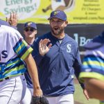 AquaSox pitching coach Matt Carasiti high-fives players before the start of a game on Thursday, July 24, 2025 in Everett, Washington. (Olivia Vanni / The Herald)