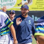 AquaSox pitching coach Matt Carasiti high-fives players before the start of a game on Thursday, July 24, 2025 in Everett, Washington. (Olivia Vanni / The Herald)