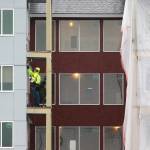 A man works on a balcony at the Cedar Pointe Apartments, a 255 apartment complex for seniors 55+, on Jan. 6, 2020, in Arlington, Washington. (Andy Bronson/The Herald)