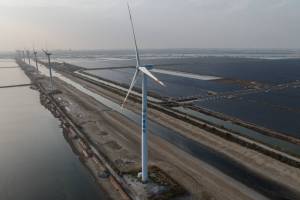 FILE — A coal-fired power plant and a wind turbine in Weifang, in Shandong Province, China, on Oct. 23, 2023. China installed more solar panels and wind turbines in 2024 than the rest of the world combined. (Gilles Sabrie/The New York Times)