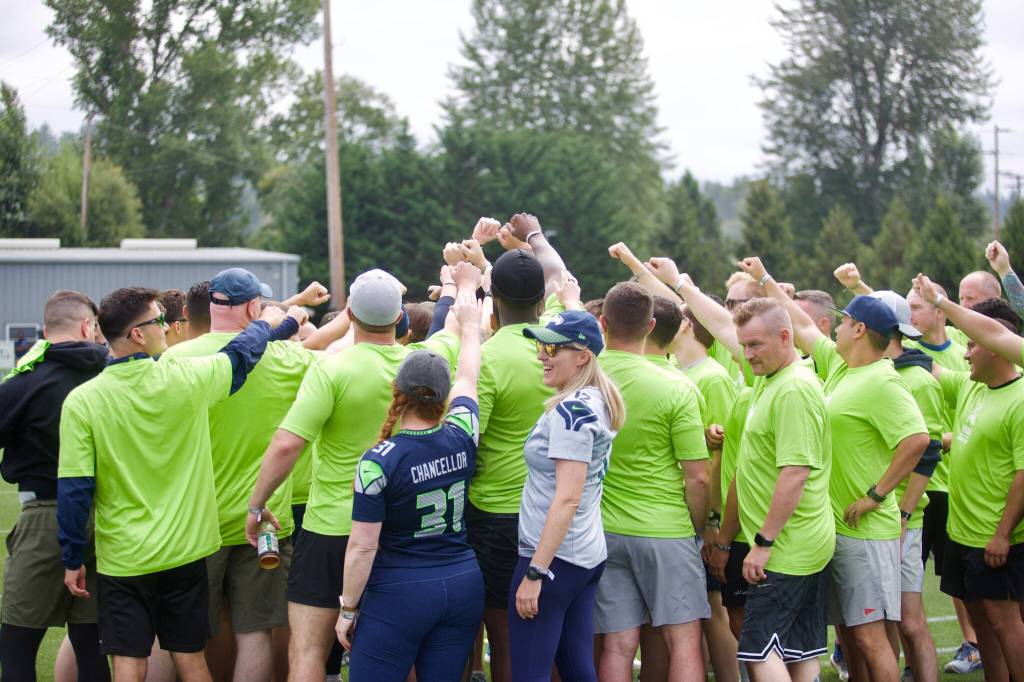 Participants gather for a group huddle during the USAAs Salute to Service NFL Boot Camp hosted by the Seattle Seahawks at Virginia Mason Athletic Center on Aug. 4, 2025. (Joe Pohoryles / The Herald)