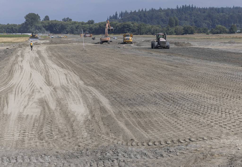 Construction vehicles work along what will be the new levy on Monday, Aug. 4, 2025 in Stanwood, Washington. (Olivia Vanni / The Herald)