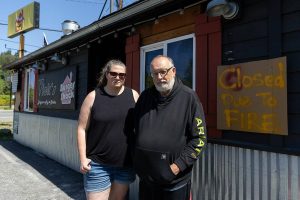 Jen Vick, left, and her father Marc Vick, right, one of the co-owners of Vick’s Burger Shack stand in front of their business on Wednesday, Aug. 13, 2025 in Sultan, Washington. (Olivia Vanni / The Herald)
