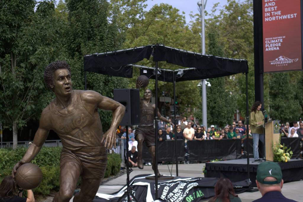 Seattle SuperSonics champion Lenny Wilkens statue is pictured alongside Seattle Storm Hall-of-Famer Sue Birds recently unveiled statue on Sunday, Aug. 17, 2025 outside of Climate Pledge Arena in Seattle. (Qasim Ali / The Herald)