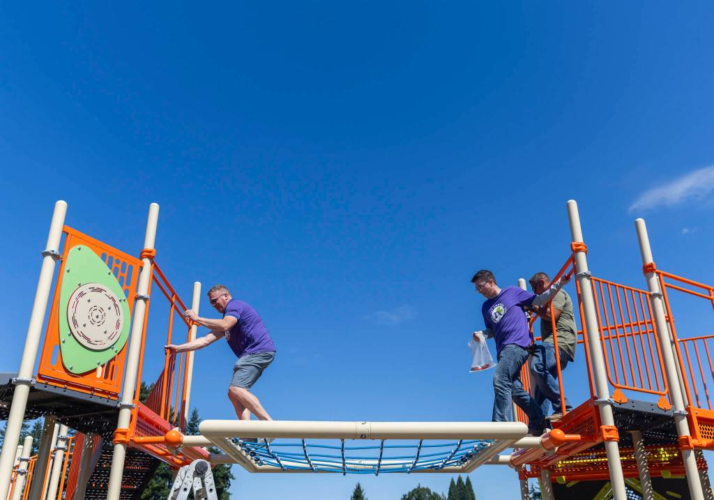 Travis Hammond, left, and Chris McGravey navigate their way across a play structure on Wednesday, Aug. 20, 2025 in Marysville, Washington. (Olivia Vanni / The Herald)