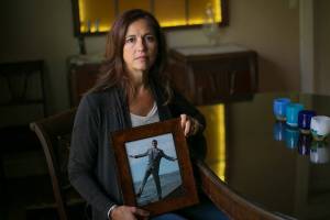 Cathi Lee holds a photo of her son, Corey, at the Lee family home Wednesday, August 30, 2023, in Everett, Washington. Lee has been involved in organizing local events for Overdose Awareness Day in the years since Corey’s death in 2015. (Ryan Berry / The Herald)