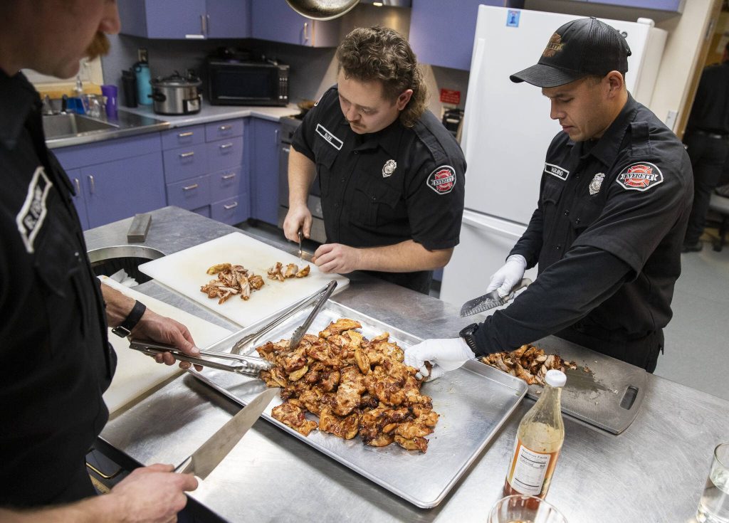 Everett firefighters chop up chicken for stir-fry. (Olivia Vanni / The Herald)
Everett firefighters chop up chicken for stir-fry. (Olivia Vanni / The Herald)