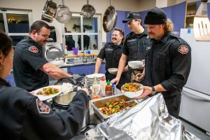 Fire Station One firefighters fill their bowls and plates with dinner on Tuesday, Dec. 10, 2024 in Everett, Washington. (Olivia Vanni / The Herald)