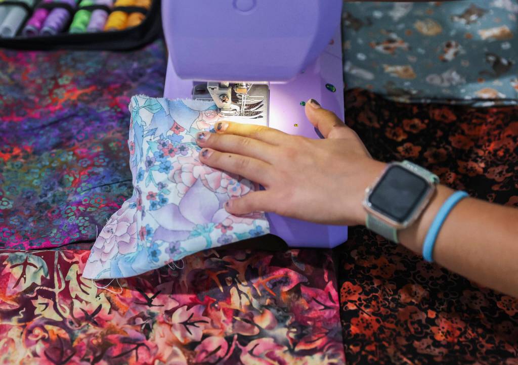 Eisley Lewis, 9, demonstrates a basic stitch with her lavender sewing machine on Wednesday, Aug. 27, 2025, in Everett, Washington. (Olivia Vanni / The Herald)