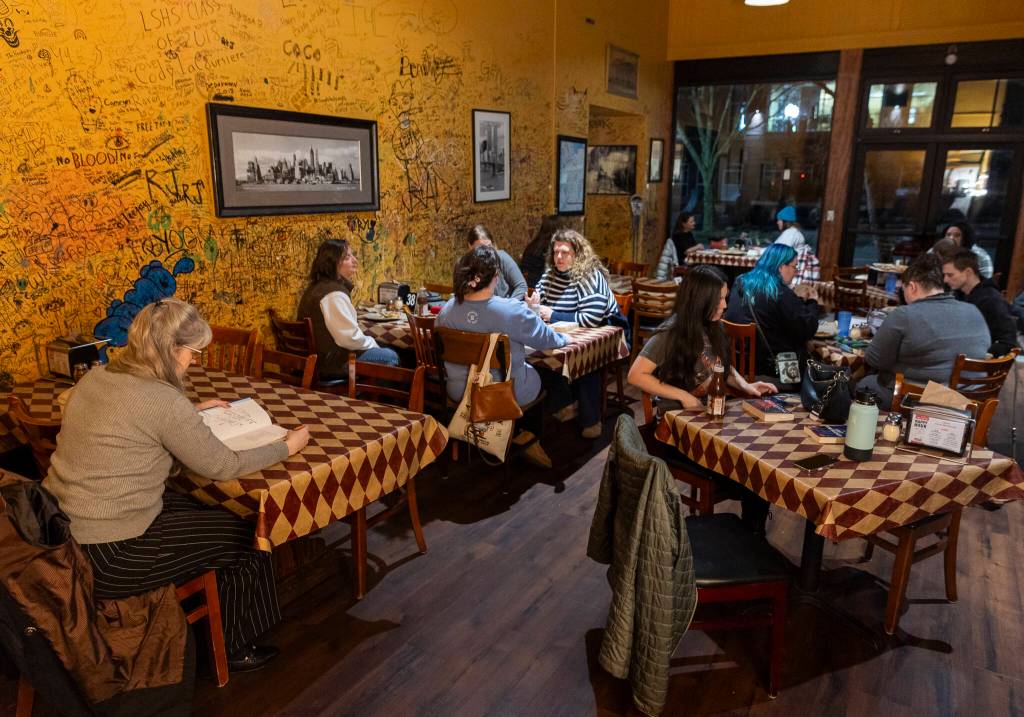 People gather at Brooklyn Bros. Pizzeria in Everett for the Silent Book Club. (Olivia Vanni / The Herald)