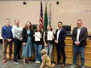 Taylor Scott Richmond
From left, County Council members Nate Nehring, Strom Peterson and Megan Dunn stand with Ella Estes and Reese Estes, their dog Cooper and council members Jared Mead and Sam Low after September 2025 was recognized as Childhood Cancer Awareness Month in Snohomish County on Tuesday. Ella and Reese both hold signed copies of the resolution.