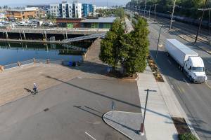A semi truck and a unicycler move along two sections of Marine View Drive and Port Gardner Landing that will be closed due to bulkhead construction on Wednesday, Sept. 3, 2025 in Everett, Washington. (Olivia Vanni / The Herald)