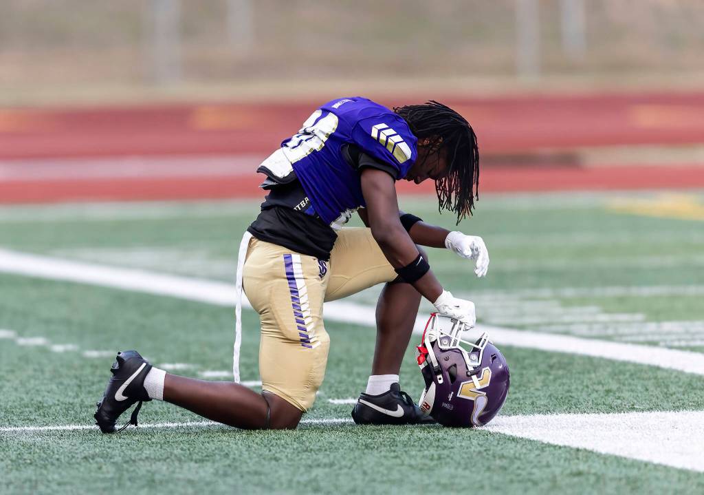 A Lake Stevens player takes a knee before the start of the game against Sumner on Friday, Sept. 5, 2025 in Lake Stevens, Washington. (Olivia Vanni / The Herald)