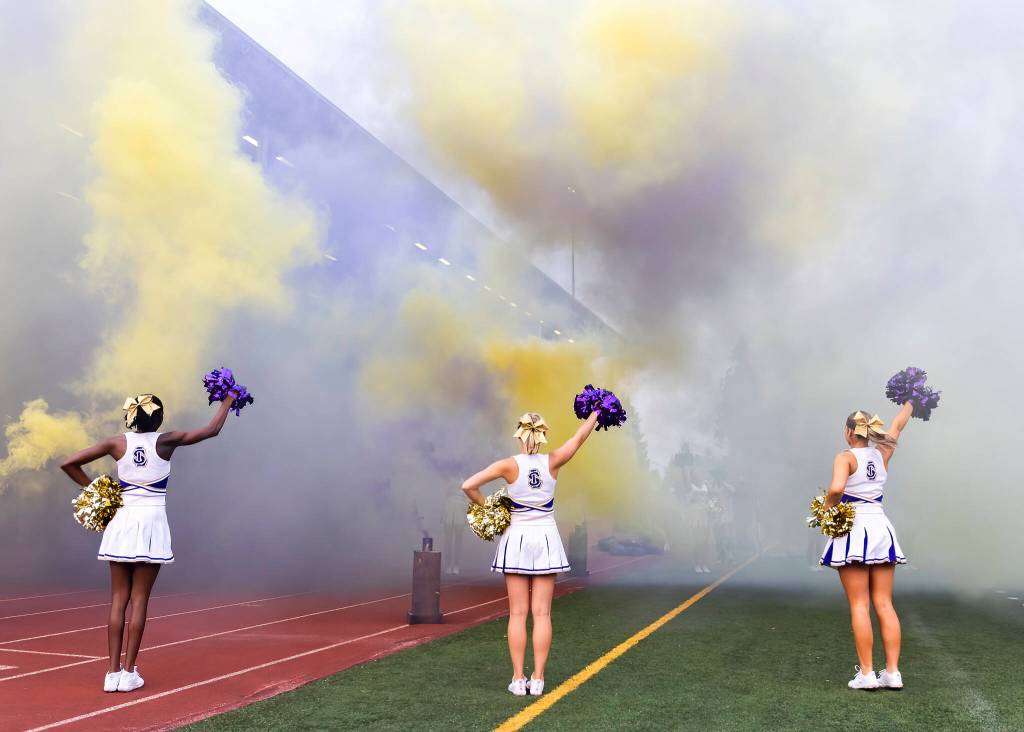 Lake Stevens cheerleaders wave pompoms while players run onto the field during the game against Sumner on Friday, Sept. 5, 2025 in Lake Stevens, Washington. (Olivia Vanni / The Herald)