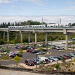 A Link train passes over a parking lot south of the Lynnwood City Center Station on Monday, Aug. 12, 2024 in Lynnwood, Washington. (Olivia Vanni / The Herald)