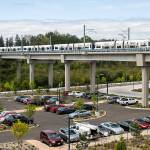A Link train passes over a parking lot south of the Lynnwood City Center Station on Monday, Aug. 12, 2024 in Lynnwood, Washington. (Olivia Vanni / The Herald)
