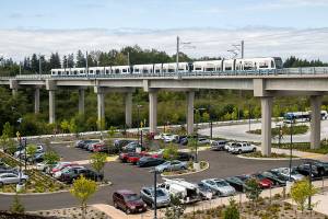 A Link train passes over a parking lot south of the Lynnwood City Center Station on Monday, Aug. 12, 2024 in Lynnwood, Washington. (Olivia Vanni / The Herald)