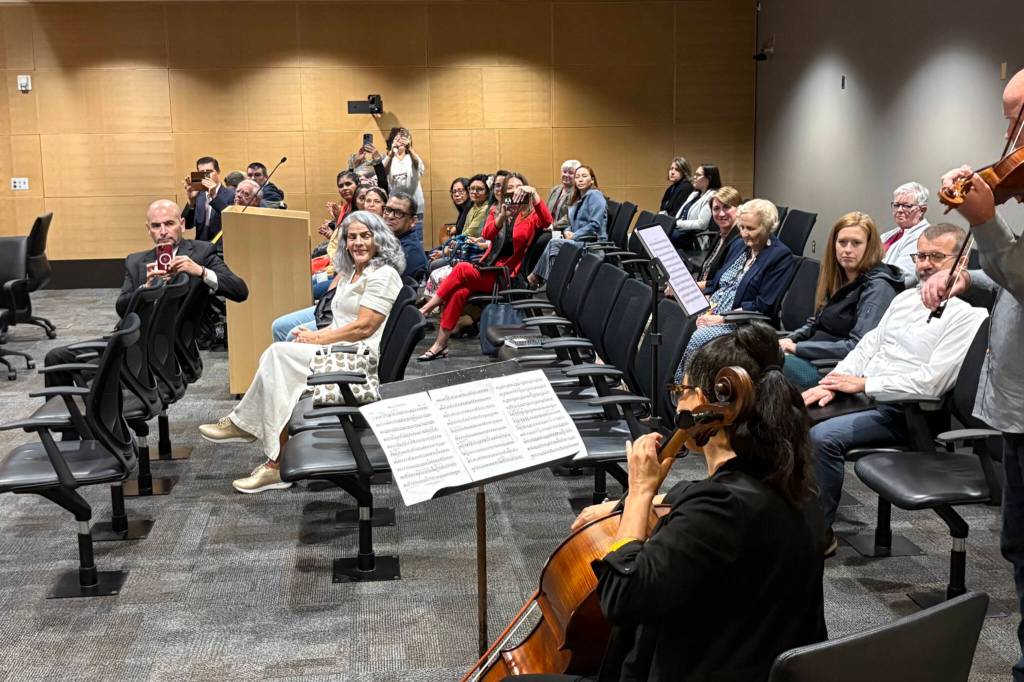 Audience members watch as Paula Madrigal, on cello, and Teo Benson, on violin, perform Mexican Overature by Merle J. Isaac during a Snohomish County general legislative session on Wednesday in recognition of Hispanic Heritage Month in Everett.