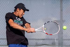 David Song jumps in the air to hit the ball during the district championship singles match on Thursday, Oct. 24, 2024 in Snohomish, Washington. (Olivia Vanni / The Herald)