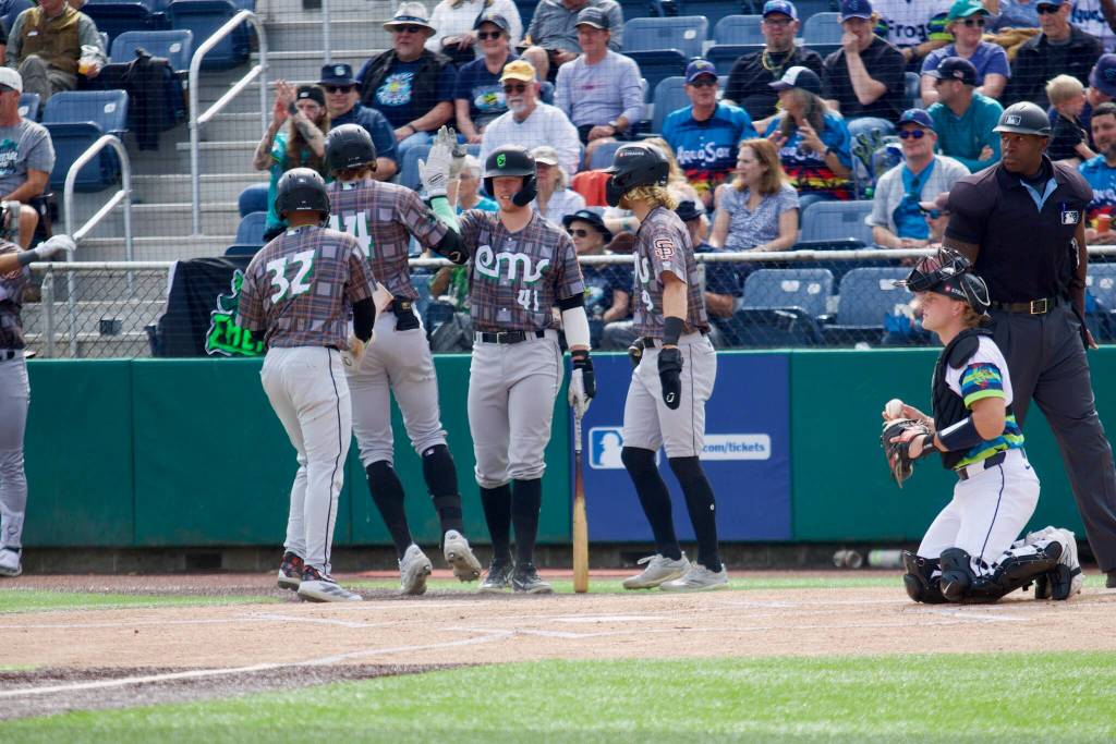 Emeralds third baseman Parks Harber (41) high-fives first baseman Charlie Szykowny (14) after Szykowny hit a three-run home run in the top of the first inning against the Everett AquaSox in Game 3 of the 2025 Northwest League Championship Series at Funko Field on Sept. 12, 2025. (Joe Pohoryles / The Herald)