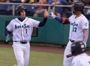 Everett AquaSox infielder Colt Emerson gets a high-five from teammate Lazaro Montes after scoring during the game against the Tri-City Dust Devils on Tuesday, May 6, 2025 in Everett, Washington. (Olivia Vanni / The Herald)