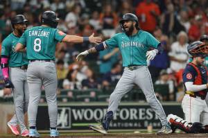 J.P. Crawford (3) of the Seattle Mariners celebrates with Dominic Canzone (8) of the Seattle Mariners after hitting a grand slam in the second inning against the Houston Astros at Daikin Park on Sunday, Sept. 21, 2025, in Houston. (Tim Warner / Getty Images / Tribune News Services)
