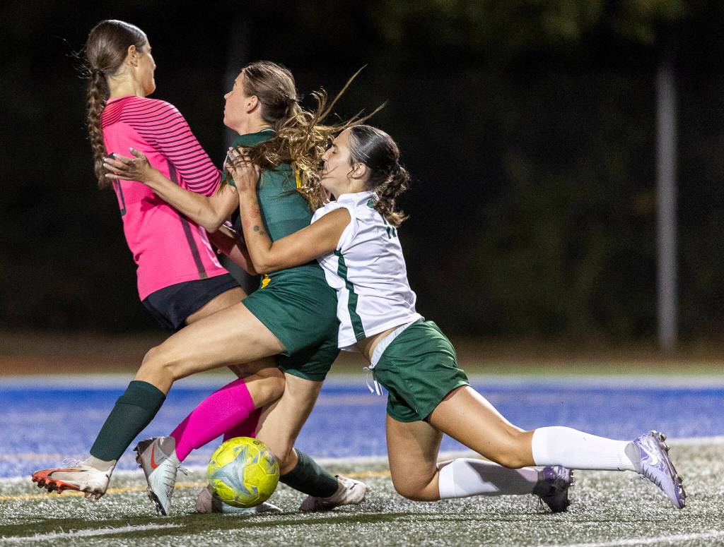Edmonds-Woodways Madalyn Bryant collides with Shorecrests Sydney Beer and Shorecrests Mickie McNeil in the goal box during the game on Sept. 23, 2025 in Shoreline, Washington. (Olivia Vanni / The Herald)