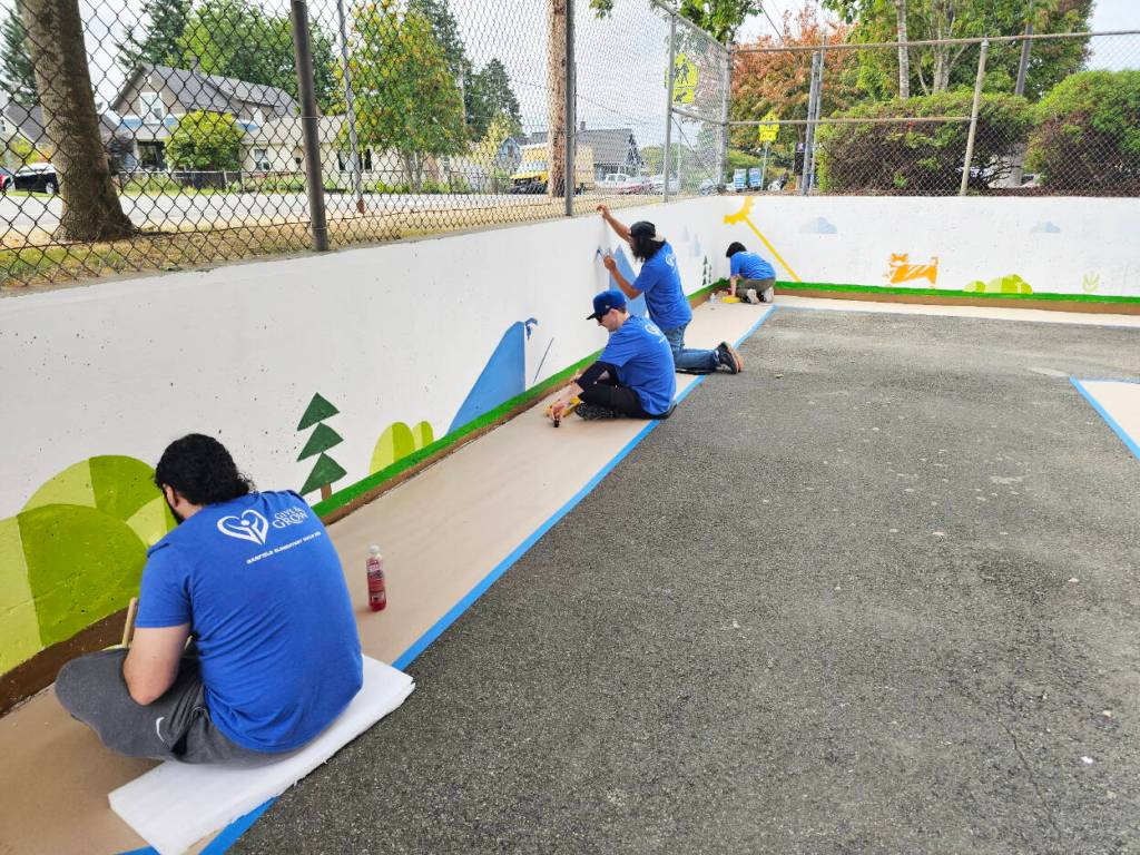 More than 90 volunteers helped paint graphics on the Garfield Elementary School playground and inside the gym and built decorative paw prints on Sept. 12 in Everett. (Photo provided)