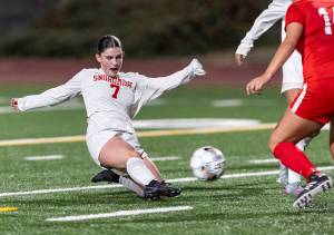 Snohomish’s Jo Cort takes a shot on goal as she slides to the ground in the goal box during the game against Stanwood on Sept. 25, 2025 in Stanwood, Washington. (Olivia Vanni / The Herald)
