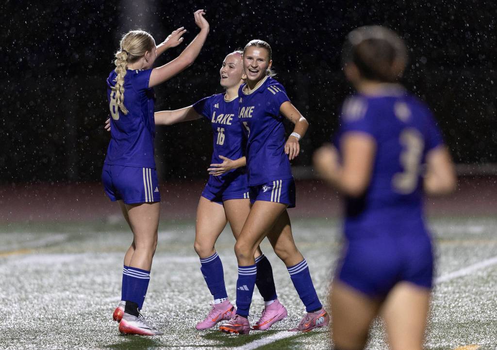Lake Stevens Carley Robertson, left, Shelby Clifton, center, and Whitney Bird, right, hug after scoring a goal during the game against Kamiak on Sept. 30, 2025 in Lake Stevens, Washington. (Olivia Vanni / The Herald)
