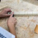 Joey Cantu, 12, lines up his handsaw with a pre-marked fret line on the neck of his canjo during class on Oct. 7, 2025 in Lake Stevens, Washington. (Olivia Vanni / The Herald)