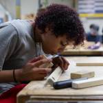 Tayalynn Jackson, 12, blows sawdust off the neck of her canjo during class on Oct. 7, 2025 in Lake Stevens, Washington. (Olivia Vanni / The Herald)