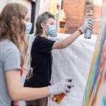Nick Lawing, 13, right, and Kayak Pidgeon, 14, right, spray paint a canvas during Teen Night at the Schack Art Center on Sept. 18, 2025 in Everett, Washington. (Olivia Vanni / The Herald)