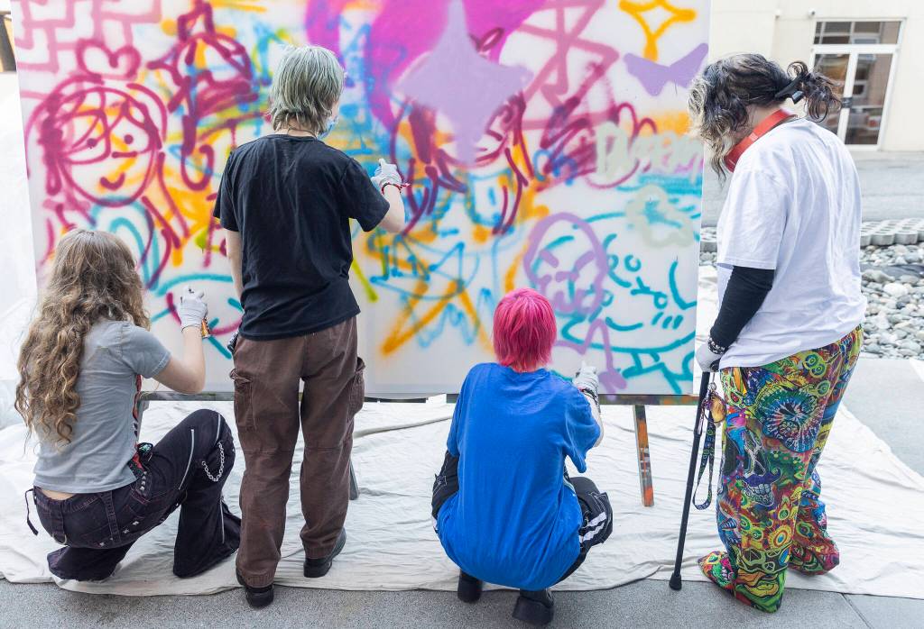 A handful of teens work on a collaborative graffiti project during Teen Night at the Schack Art Center on Sept. 18, 2025 in Everett, Washington. (Olivia Vanni / The Herald)