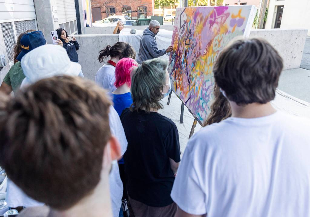 Graffiti artist AYE147 works on a collaborative project during Teen Night at the Schack Art Center on Sept. 18, 2025 in Everett, Washington. (Olivia Vanni / The Herald)